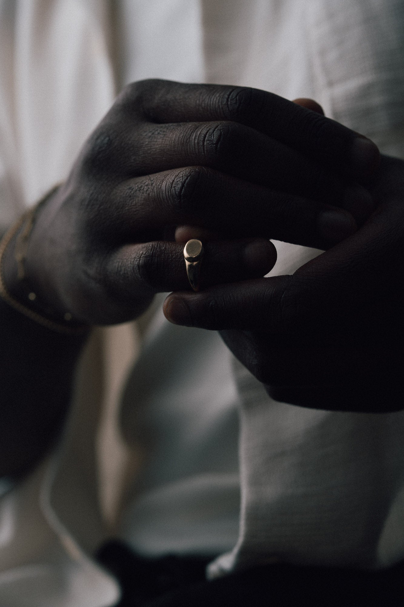 Close-up of a hand wearing a genderless signet ring made of recycled gold