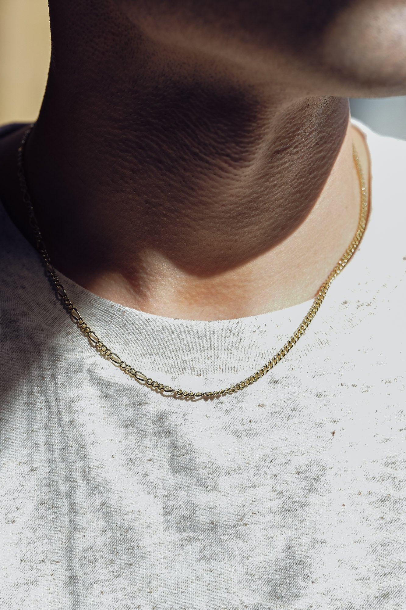 Close-up of a man wearing a the gold chain necklace with unique design made in London