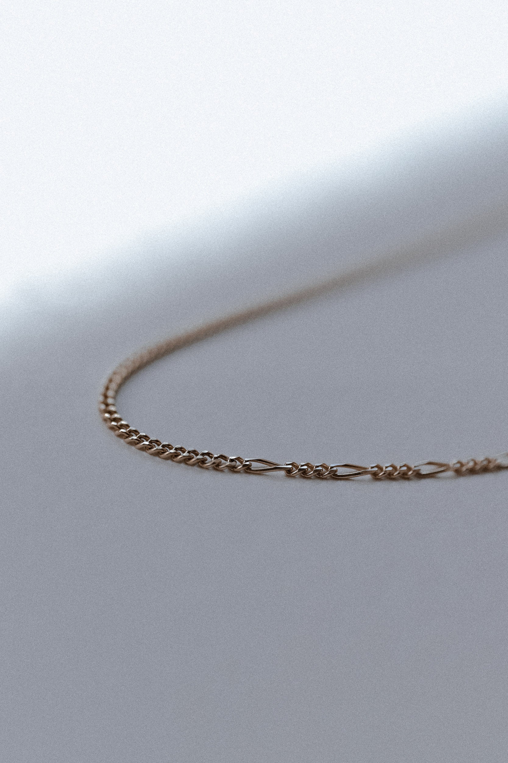 Gold chain necklace on close up with unique linked design 