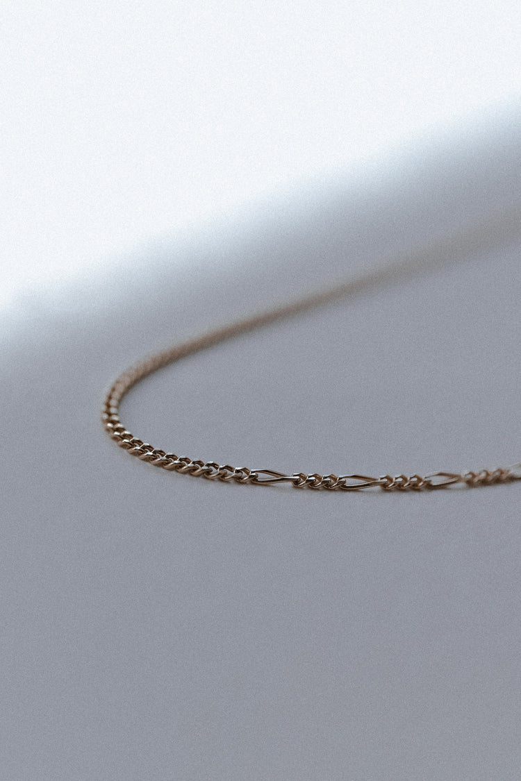 Gold chain necklace on close up with unique linked design 