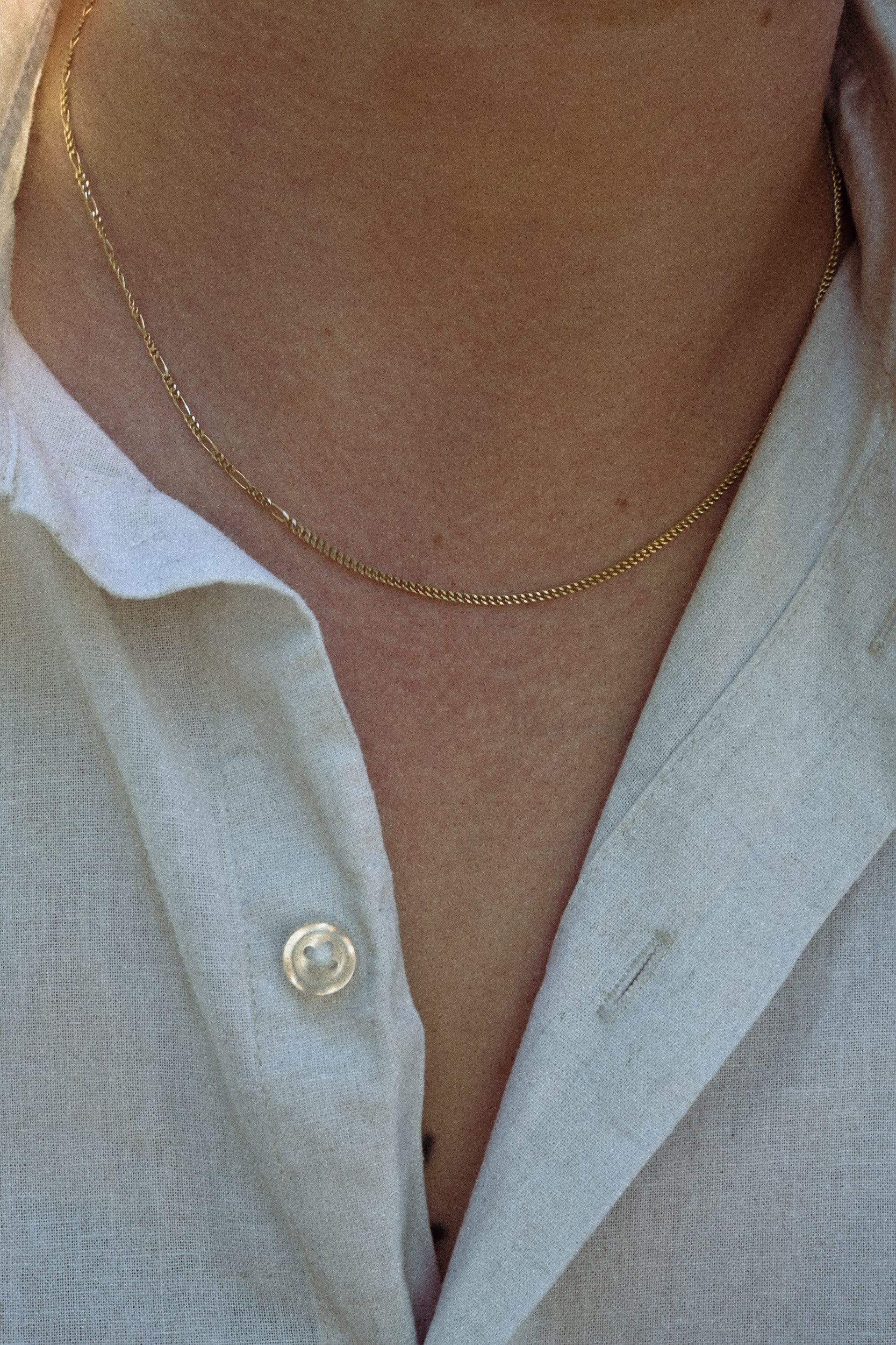 Close-up of a person wearing a gold necklace with unique style made in London 