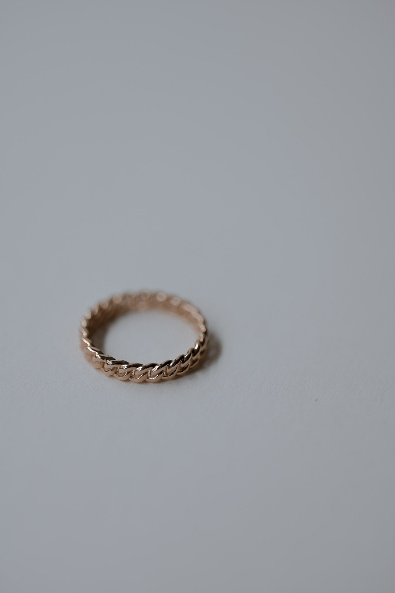 Beautiful gold ring with rope design on a light gray background