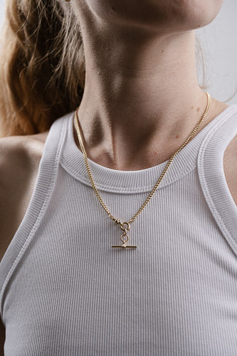 Woman wearing recycled gold pendant necklace with curb chain